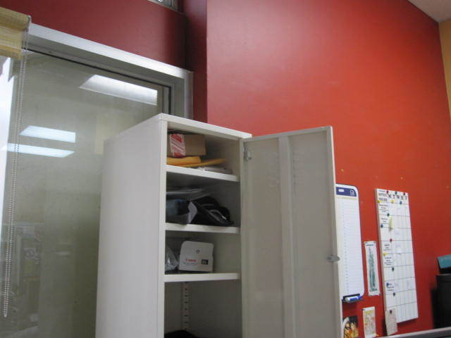 Photo of open cupboard in office.