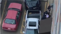 Screengrab from the bystander video shows officers pushing a handcuffed Parkhurst towards a brick wall